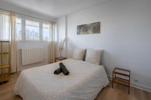 a bedroom with a large bed with a black object on it at The Sunrise, Spacious, fully equipped, 2 parkings, 8p, tramway 1,2,4 in Montpellier
