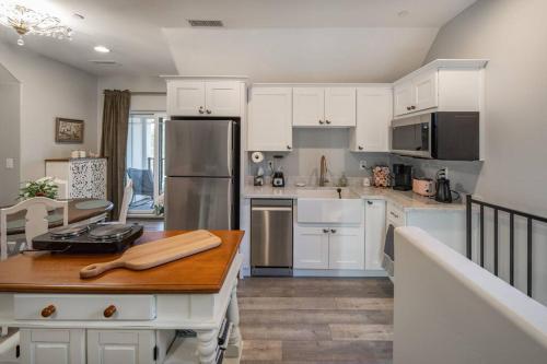 a kitchen with white cabinets and a wooden table at Fawn Chalet in the Prescott Pines Near Downtown in Prescott