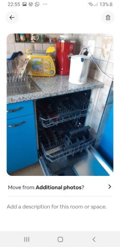 a kitchen with an open dishwasher in a counter at Central quiet and cosy apartment near Hallenstadion in Zürich
