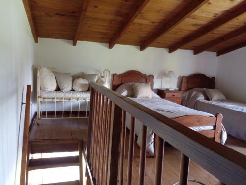 een kamer met 2 bedden en een balkon met een trap bij POSADA EL ROMANCE in Tandil