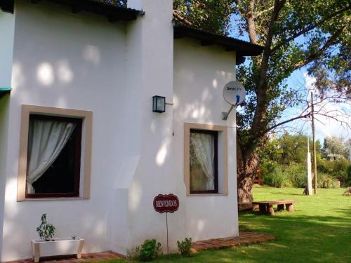 een wit huis met een bord erop bij POSADA EL ROMANCE in Tandil