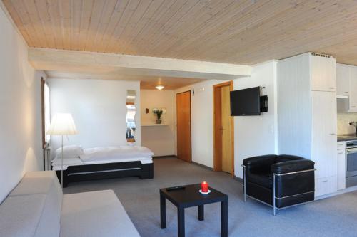 a living room with a bed and a table with a candle at Apartment Lenkstrasse 6 C in Lenk