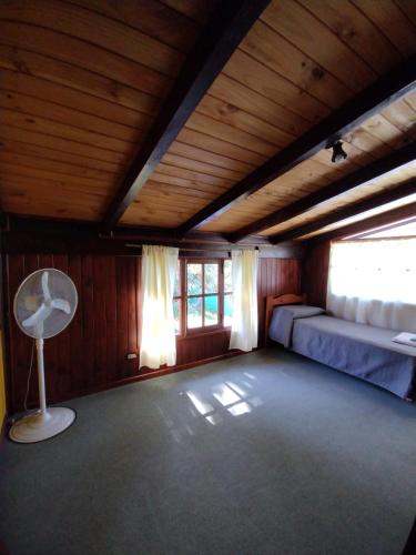 a large room with two beds and a fan at Cabañas Lamani in Lago Puelo