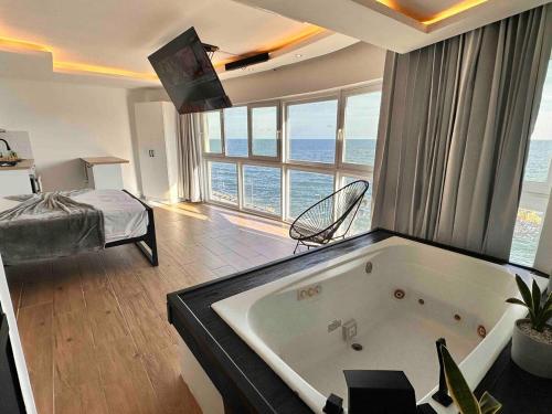 a large room with a bath tub with a view of the ocean at Villa Marbella by Potenza Rentals in Santo Domingo