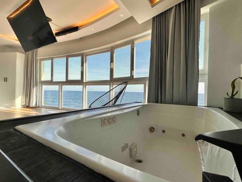 a large bath tub in a room with a large window at Villa Marbella by Potenza Rentals in Santo Domingo