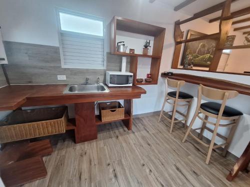 a kitchen with a sink and a counter with stools at Villa Coral in Hucares