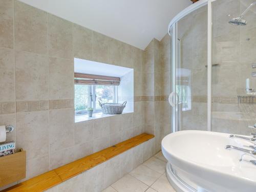 a bathroom with a sink and a tub and a window at 3 Bed in Presteigne 78350 in Kinsham