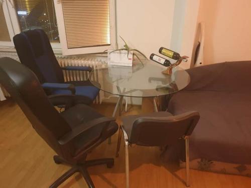 a glass table and chairs in a living room at Jonny room in Trnávka