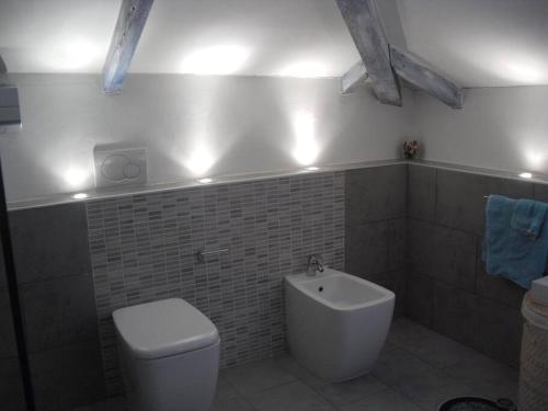baño con aseo y lavabo con luces en Appartamento romantico indipendente, en Gaglianico