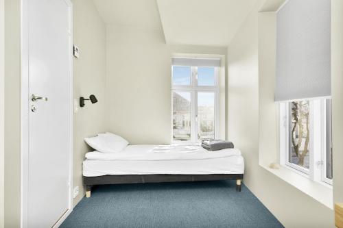 uma cama num quarto com uma janela em Central Guest House - Bedroom with en suite Bathroom em Stavanger