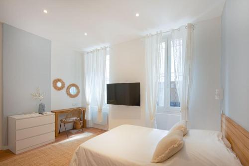 une chambre blanche avec un lit blanc et une télévision dans l'établissement Longchamp Grand T2 haut de gamme Terrasse, à Marseille