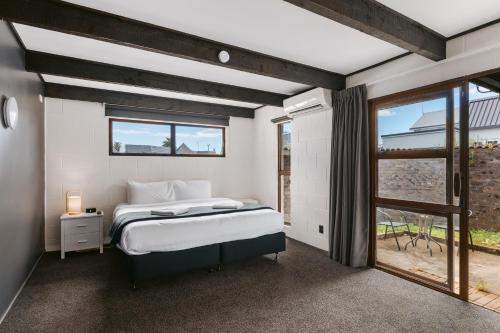 sypialnia z łóżkiem i oknem w obiekcie Rolleston Motel Thames - Wenzel Motels w mieście Thames