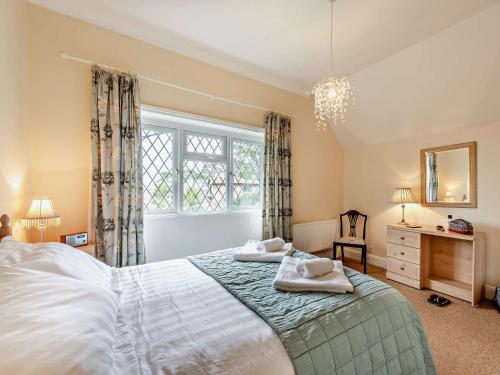 a bedroom with a large bed with two towels on it at 4 Bed in Totland Bay IC032 in Totland