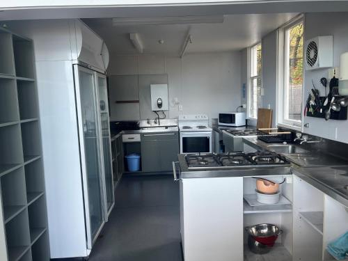 a kitchen with white cabinets and a stove top oven at Kaikoura Seaside lodge in Kaikoura