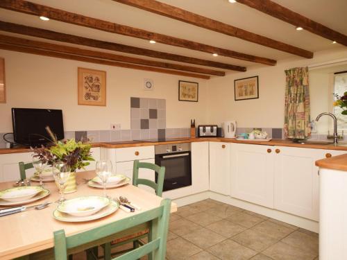 a kitchen with a table and chairs and a table and a kitchen at 2 Bed in Barnstaple LCOBB in Chittlehampton