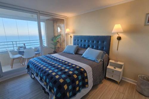 a bedroom with a bed and a balcony with a table at Frente a la playa. Vista al mar. in Concón