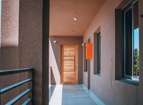a hallway of a house with a wooden door at La Cava Apartments in Ciudad Lujan de Cuyo