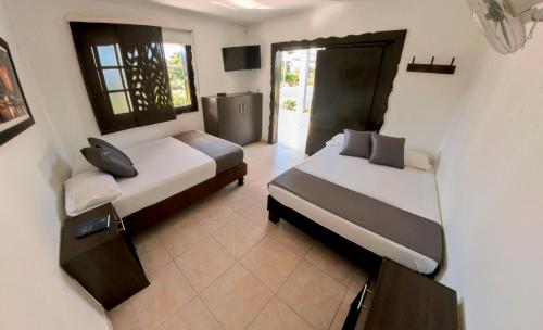 a bedroom with two beds and a television in it at Finca Hotel Palmas Del Edén in Armenia