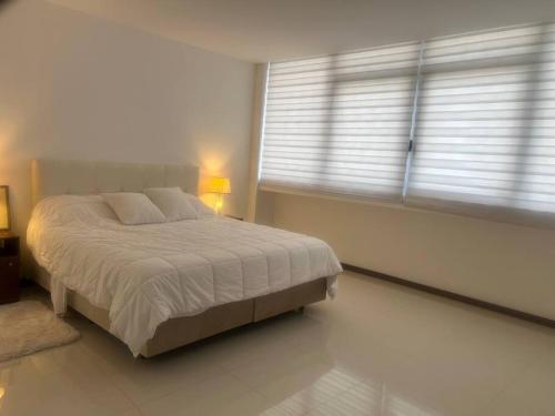 - une chambre avec un grand lit et une fenêtre dans l'établissement Su estadía perfecta Negocio o Turismo, à Santa Cruz de la Sierra