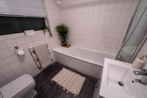 łazienka z wanną, toaletą i umywalką w obiekcie Powdermill Lodge w mieście Hanworth