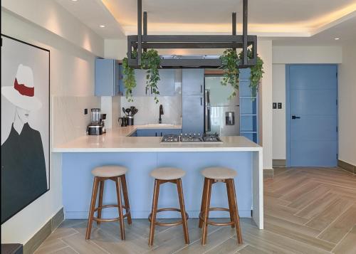 a kitchen with two bar stools and a counter at Villa Marbella by Potenza Rentals in Santo Domingo