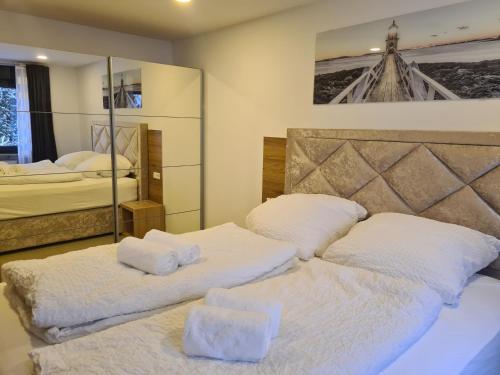 a bedroom with two beds with white sheets and a mirror at WellandHome Aalen - Private Deluxe Apartment in Aalen