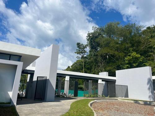 a modern house with white walls and a driveway at Punta Esmeralda by Punta Leona in Jacó