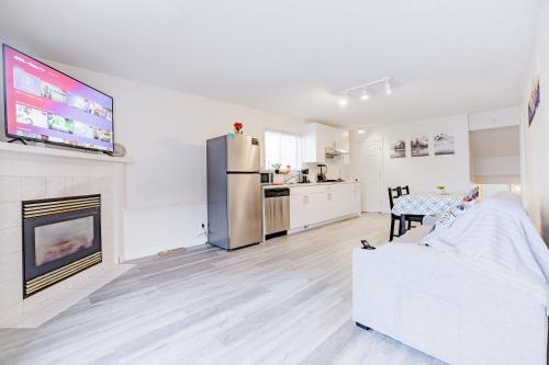 a white living room with a refrigerator and a kitchen at Walkout Basement Suite, 2 BDR 4BD, Bright and Spacious in Calgary