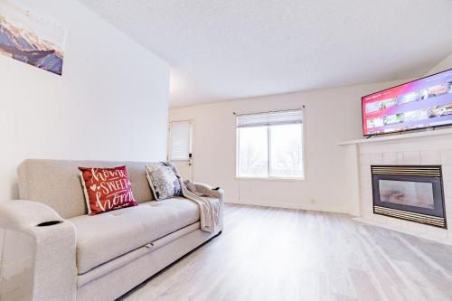 a living room with a couch and a fireplace at Walkout Basement Suite, 2 BDR 4BD, Bright and Spacious in Calgary
