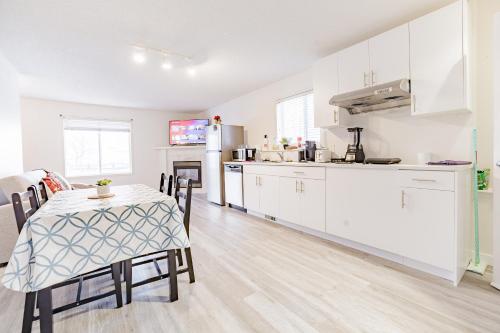 a kitchen and dining room with a table and a table and chairs at Walkout Basement Suite, 2 BDR 4BD, Bright and Spacious in Calgary