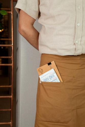 a man is wearing a brown skirt with a credit card in his pocket at Plaza San Antonio Hotel & Spa, Autograph Collection in San Antonio