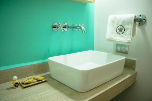 Baño con lavabo blanco y pared azul en SUITES 509 en Pachuca de Soto