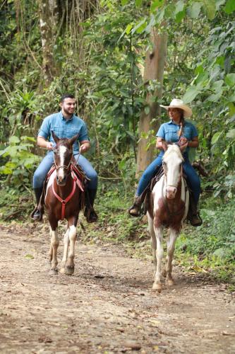 dos personas montando caballos en un camino de tierra en Chachagua Rainforest Hotel & Hot Springs en Fortuna