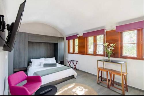 a bedroom with a bed and a table and a chair at Siete Puertas Coyoacán in Mexico City