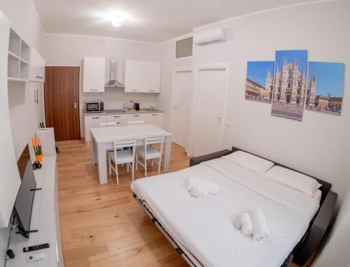 una camera con letto e una cucina con tavolo di Soperga10 a due passi da Stazione Centrale - Milano Real Estate a Milano