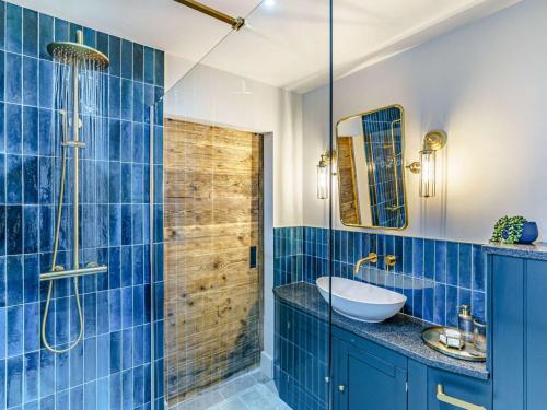 a blue tiled bathroom with a sink and a shower at 1 Bed in Durham 89318 in Witton Gilbert