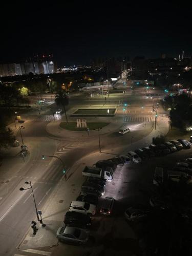a city street at night with cars parked in a parking lot at Alojamiento K&K Habitacion encasa particular in Valencia