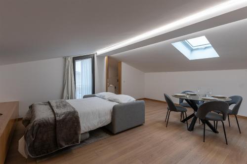 Un dormitorio con una cama y una mesa con sillas. en Direita House 131, en Braga
