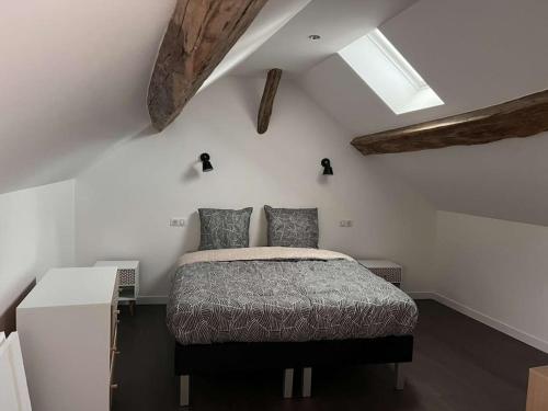 um quarto com uma cama e uma parede branca em Appartement Gîte Le Marmont em Châtillon-sur-Seine