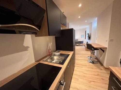 a kitchen with a sink and a desk in a room at Appartement Gîte Le Marmont in Châtillon-sur-Seine