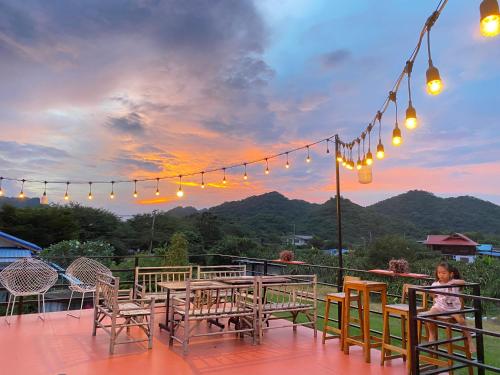 a child sitting at a table on a patio with lights at Baan I-A-run Resort in Pak Chong