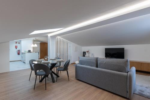 a living room with a couch and a table with chairs at Direita House 131 in Braga