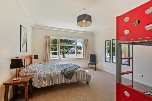 a bedroom with a bed and a desk and a window at 46 Scarborough Tce in Hanmer Springs