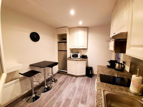 eine Küche mit zwei Barhockern und einer Mikrowelle in der Unterkunft DAJO in Cap d'Ail