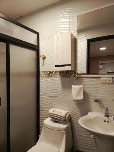 Baño pequeño con aseo y lavamanos en Mimo'Suits & rooms, en Machala