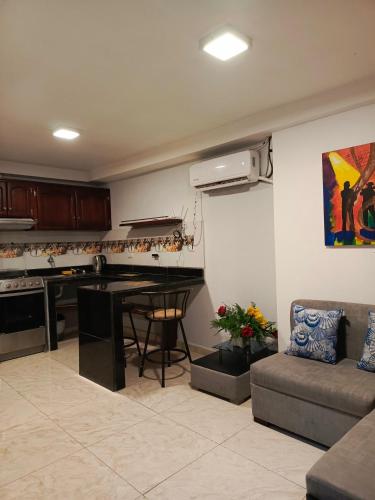 ein Wohnzimmer mit einem Tisch und einem Sofa in der Unterkunft Mimo'Suits & rooms in Machala
