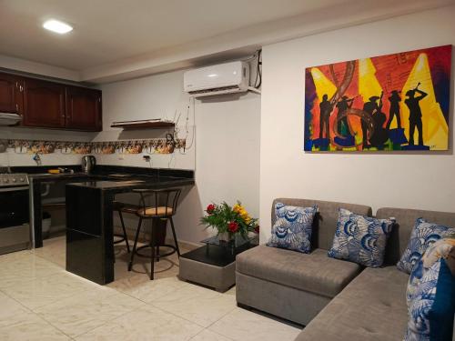 a living room with a couch and a kitchen at Mimo'Suits & rooms in Machala