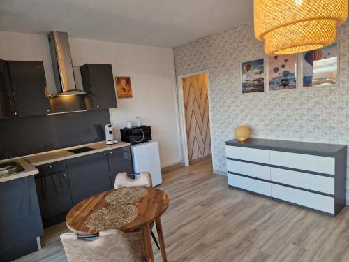 une cuisine avec une table et une petite table ainsi qu'une salle à manger dans l'établissement Studio avenue de Champagne, à Épernay