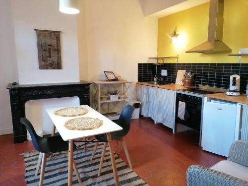 a kitchen with a table and chairs in a room at Zoralie in Agde