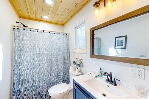 y baño con ducha, lavabo y aseo. en Last Lake Lodge, en Madawaska